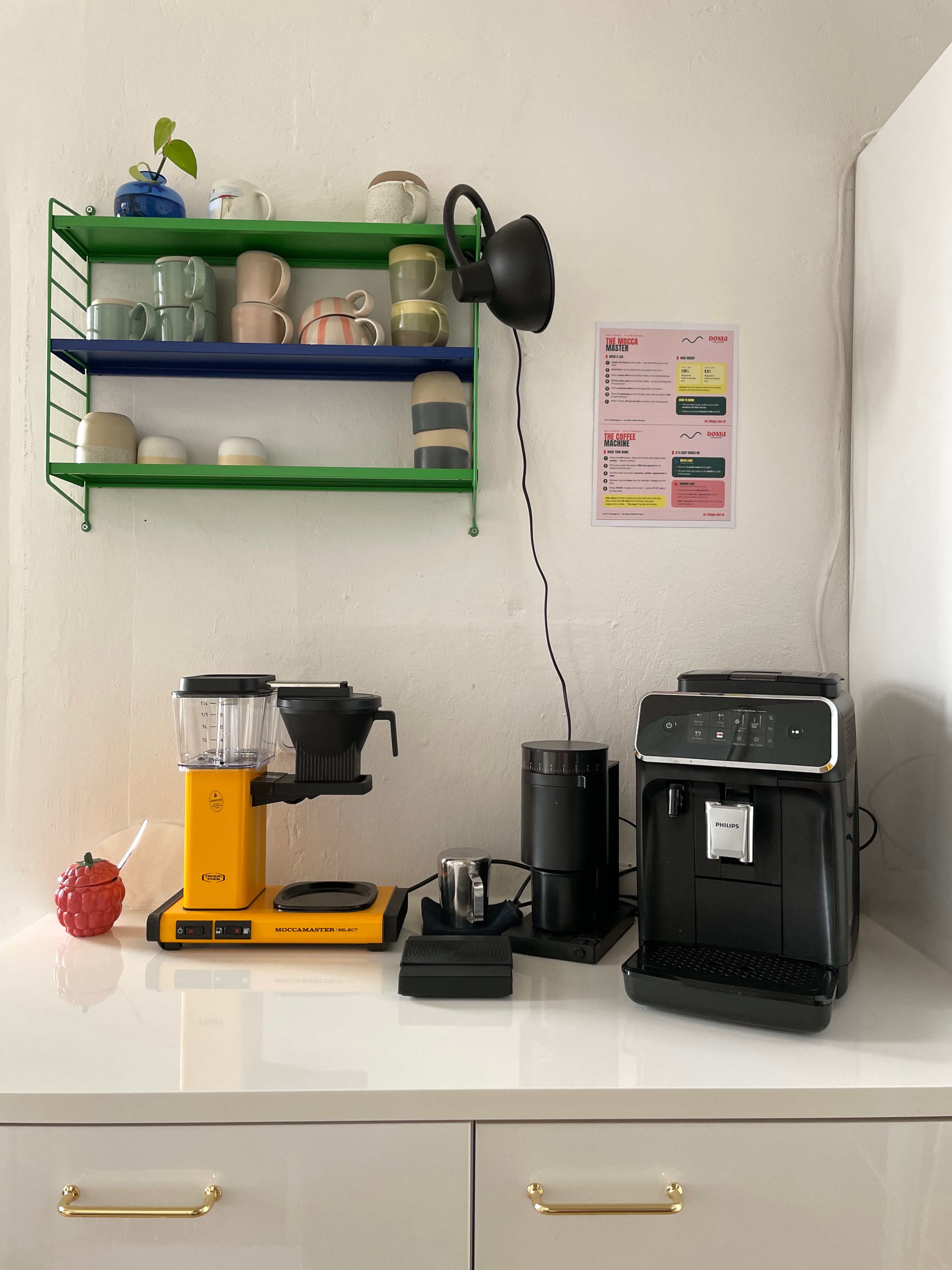 The coffee bar — filter coffee maker, espresso machine and mugs on open shelving
